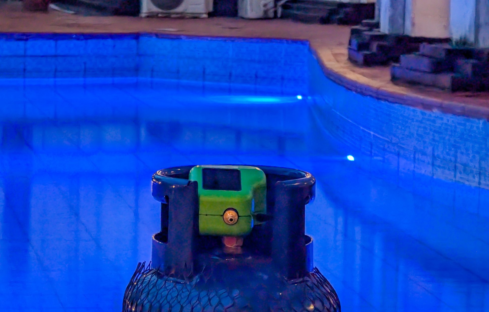 A Kibo smart meter fitted to a 12.5 kg LPG cylinder, photographed at dusk in Ikoyi, Lagos