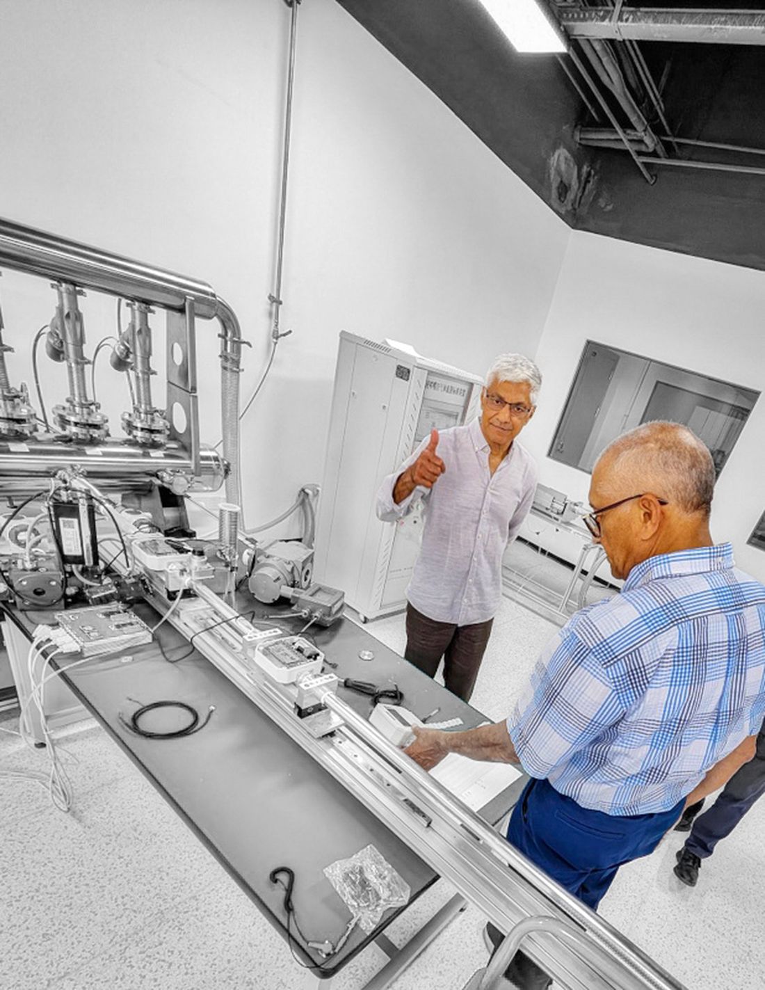 Safi's founders in the gas-metrology calibration laboratory beside a reference flow bench
