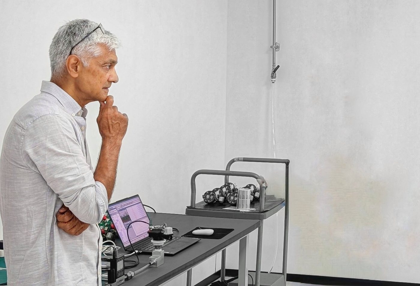Devendra Dave reviewing calibration runs beside a tray of sensor cores in the test room